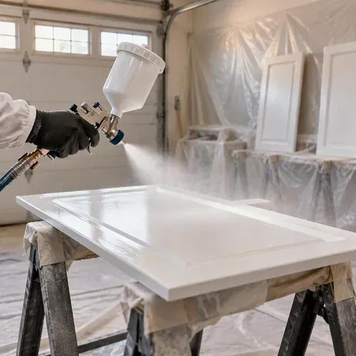 HVLP sprayer laying a smooth white finish coat on a kitchen cabinet door